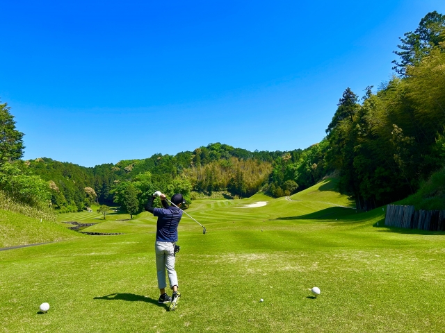 ゴルフ場でティーショットを打つシーン