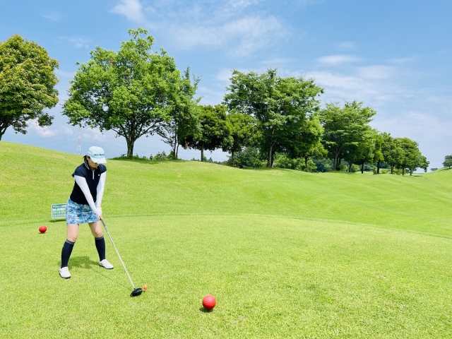 ゴルフ場でティーショットを打つ女性ゴルファー